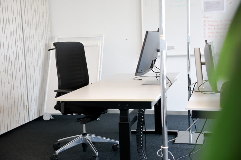 Desk with computer, chair, whiteboard, carpeted floor
