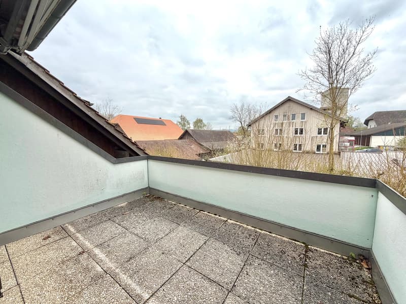 Balcony with tiled floor, white walls, metal railing, view of houses and trees