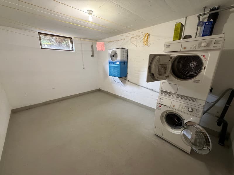 Laundry room with washing machine, dryer, and small window