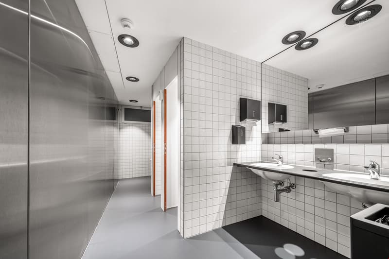 modern bathroom with white tiles, two sinks, and metal finishes