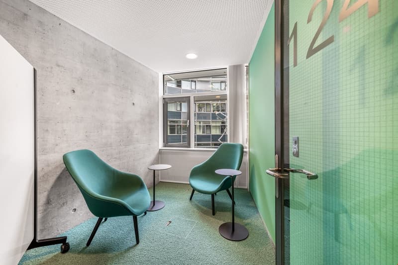 Modern design, two green chairs, small side tables, glass door, concrete wall, glass window