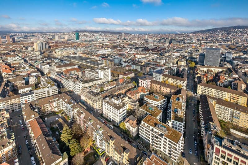 Aerial view of a city with many buildings, roads, and cars.