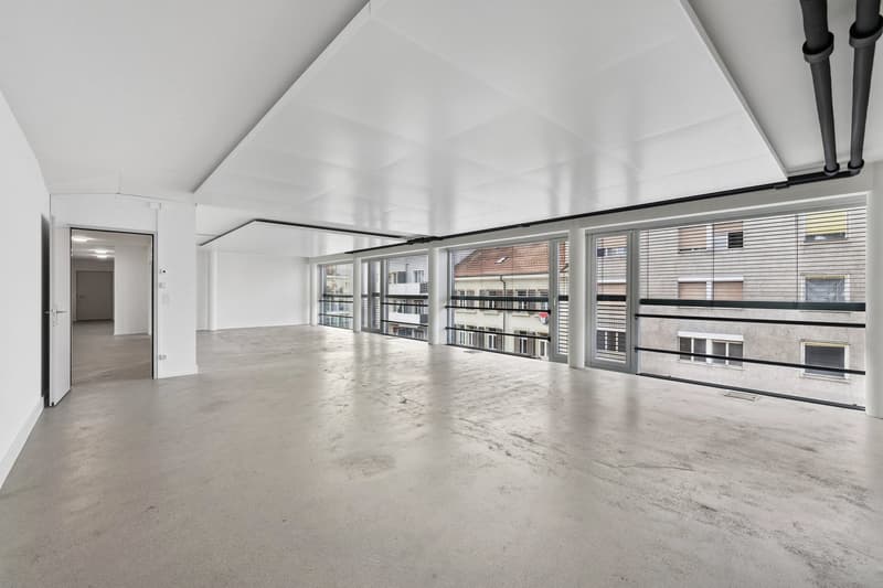 Spacious, clean, white walls, concrete floor, open doors, glass walls, balconies