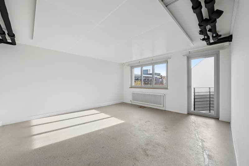 Empty room with white walls, concrete floor, radiator, glass door, glass window with outside view