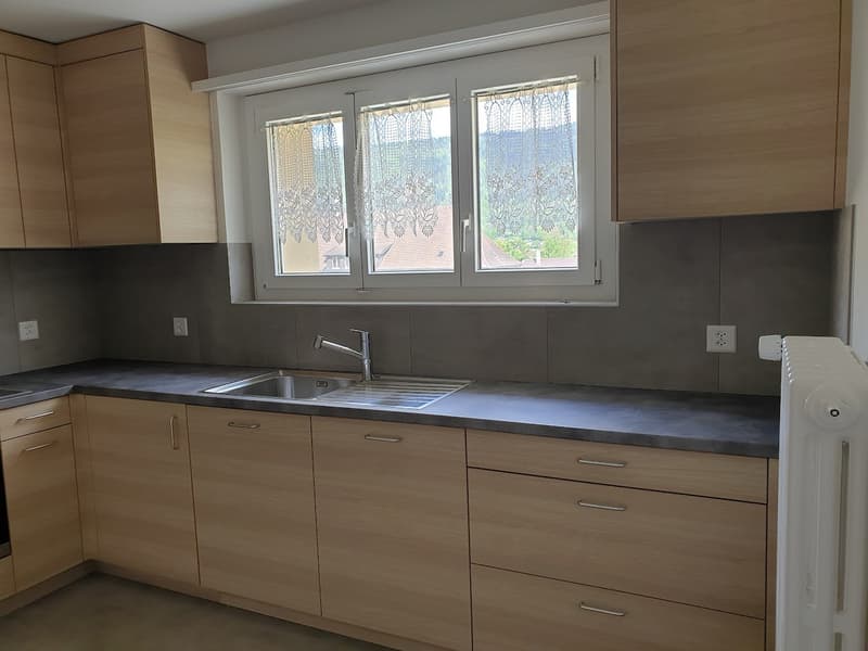 kitchen with stainless steel sink, faucet, wooden cabinets, electrical outlets, radiator
