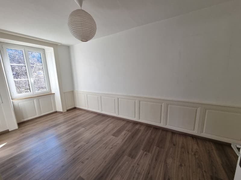 empty room with wooden flooring, white walls, a window with sill, a white ceiling with a lamp