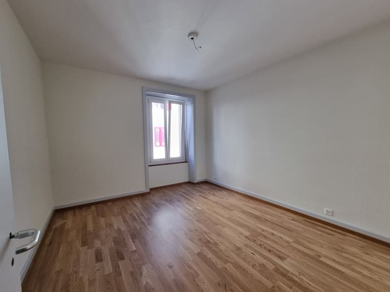 empty room, wooden floor, white walls, window, power outlet