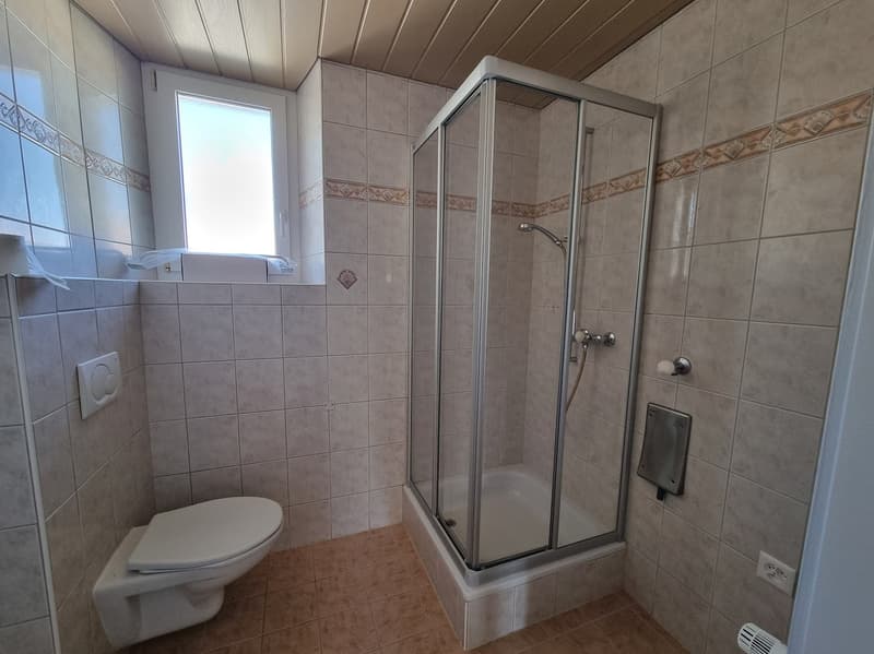 tiled walls, white toilet, glass shower enclosure, tiled floor