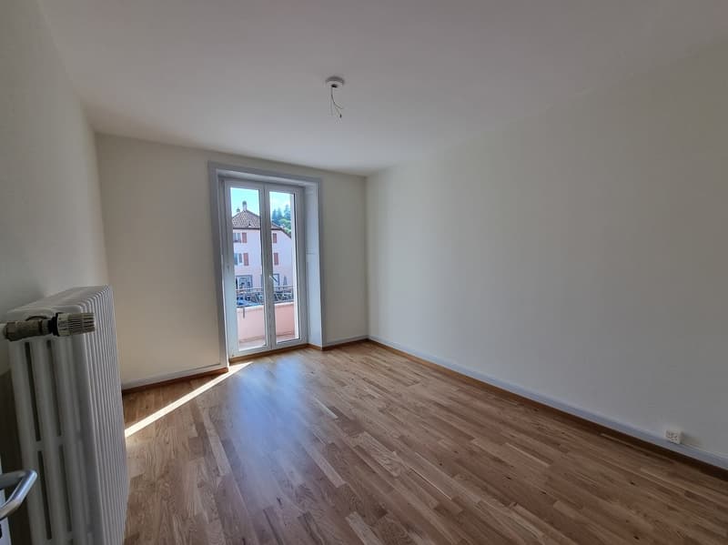 empty room, wooden floor, white walls, sliding glass door, balcony, radiator