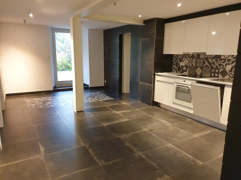 modern kitchen with white cabinets, black tiled floor, white ceiling, glass door, white rug