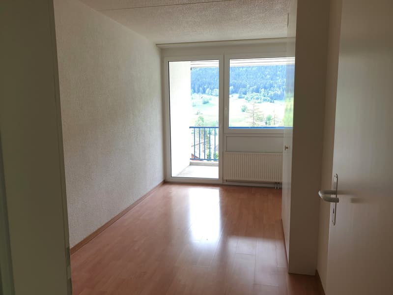 empty room, wooden floor, sliding glass door, balcony, white walls, white ceiling, white radiator