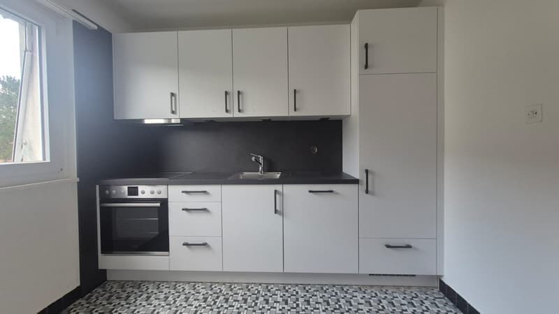 white cabinets, black countertop, stainless steel sink, oven, window, checkered floor