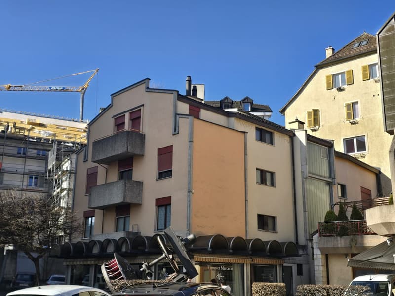5-story building, concrete and brick walls, balconies, awnings, shops, tree