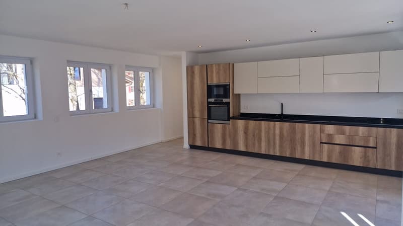 kitchen with oven, microwave, wooden cabinets, white tiles on the floor, windows