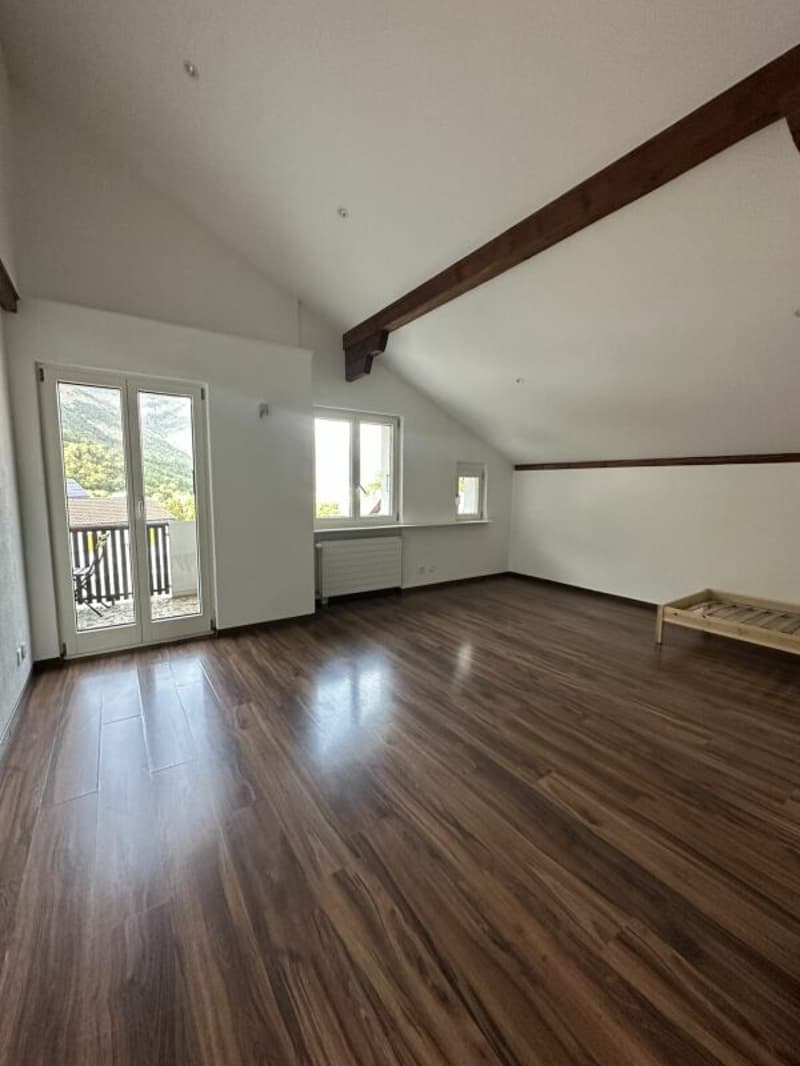 empty room, wooden floor, sliding glass door, balcony, wooden beams, white walls, windows
