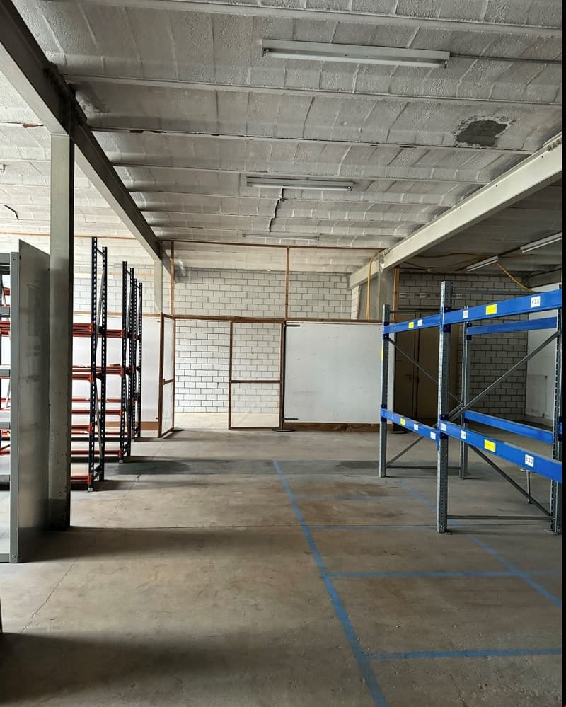 empty warehouse with brick walls, white ceiling, and two racks