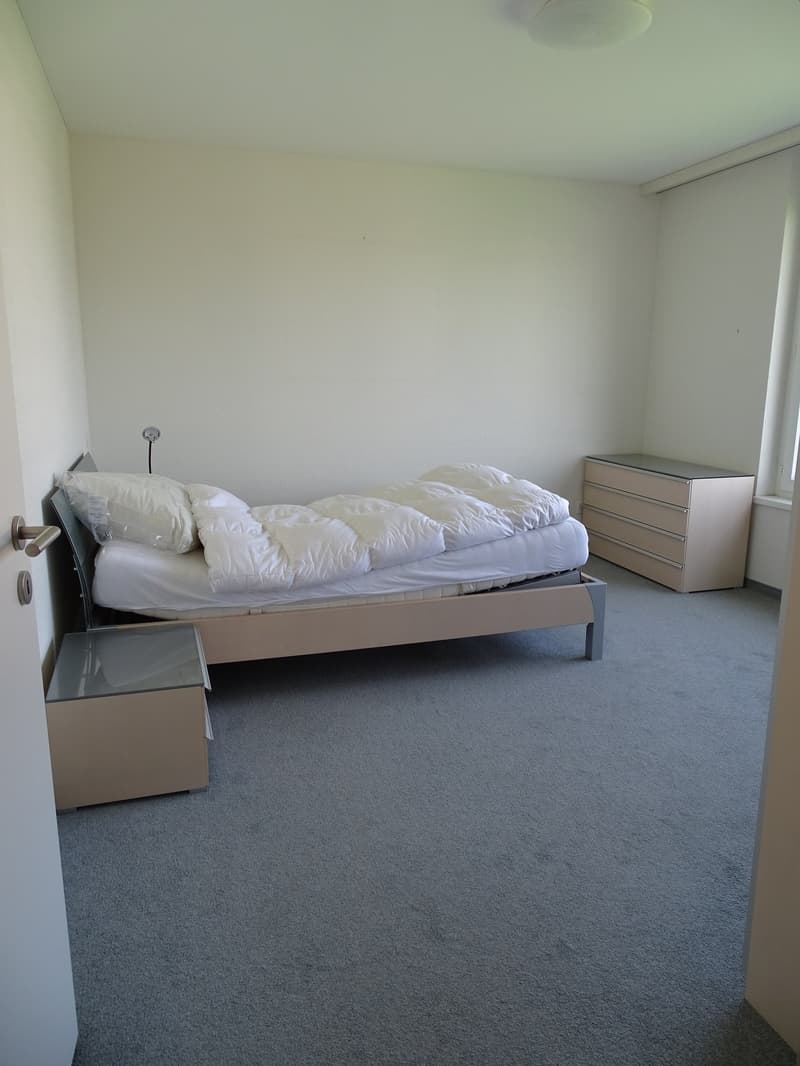 bedroom with a double bed, bedside table, and a three-drawer chest of drawers