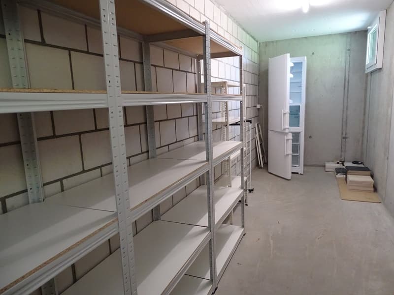 empty room with large white shelves and a white refrigerator