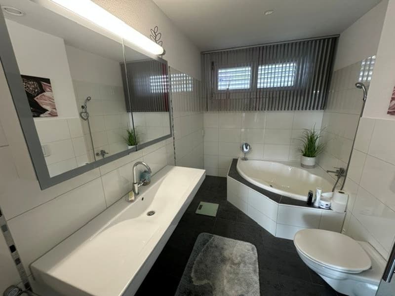 Ein Bad mit Wanne, Toilette und Lavabo
