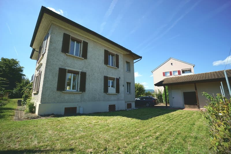 2-story house, gray walls, black windows, driveway, garage, lawn