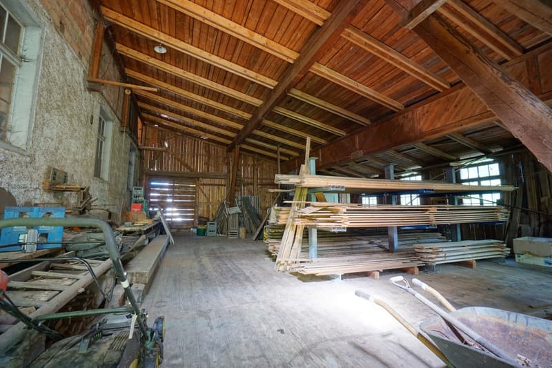 wooden ceiling, large room, stacks of wood, wooden wheels, various tools