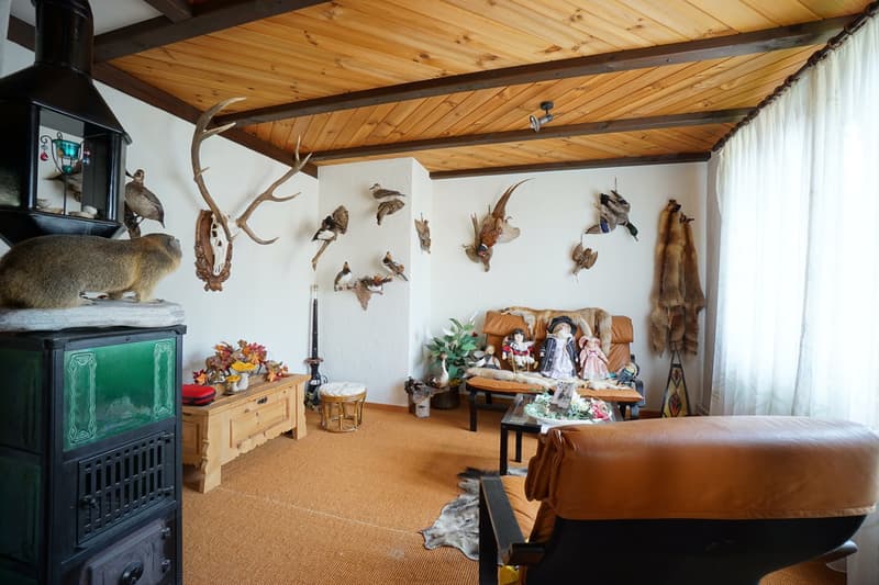 beamed ceiling, animal trophies on wall, wooden furniture, fireplace