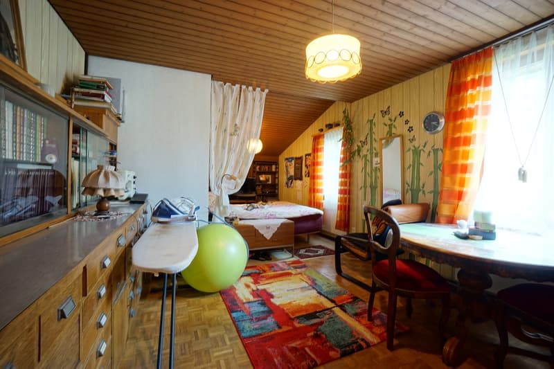 bedroom with bed, wooden cabinet, iron board, bookcase, desk, chair, rug, lamp, exercise ball