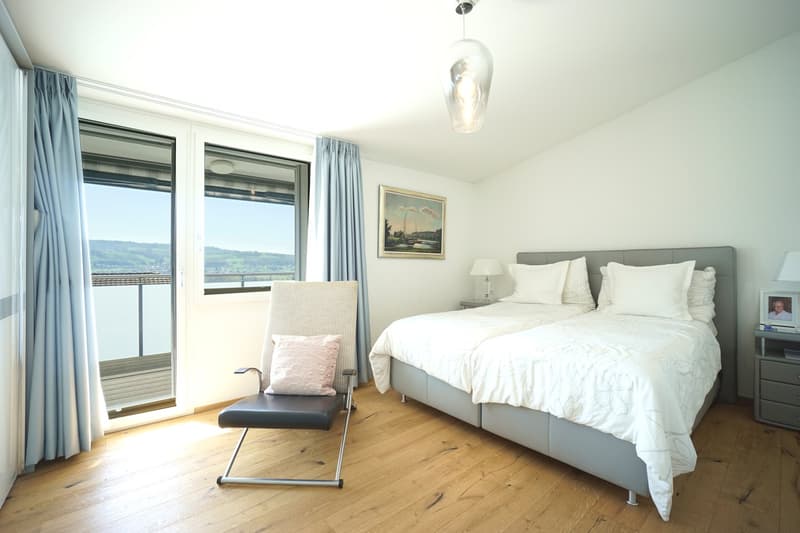 double bed, bedside tables, lamps, picture frame, chair, wooden floor, large windows, balcony, curtains