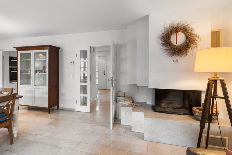 white walls, tiled floor, fireplace, cabinet, lamp, chair, table