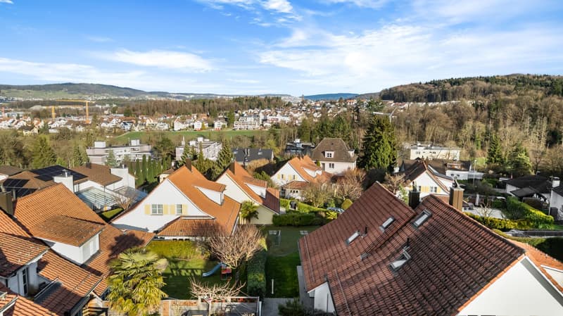 hilltop housing complex, multiple residential buildings, green hills, aerial view