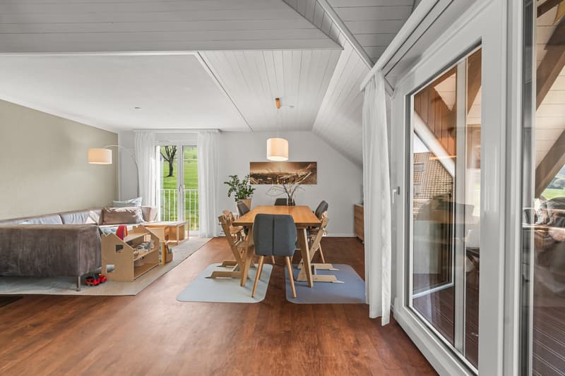 open living room with dining area, wooden floor, white walls, large windows, balcony, view of the outside