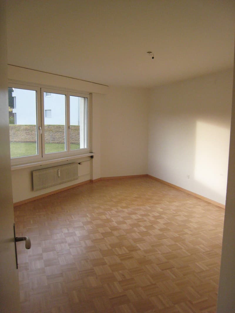 empty room, wooden floor, white walls, large window, radiator