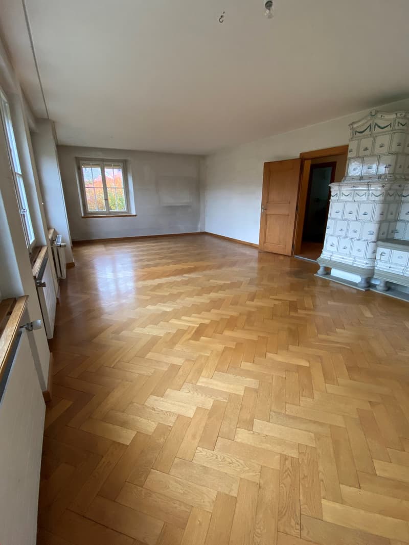 hardwood parquet floor, fireplace, white walls, windows, wooden door