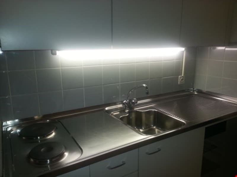 kitchen counter, sink, gas stove, built-in cabinets, tiled wall, LED light