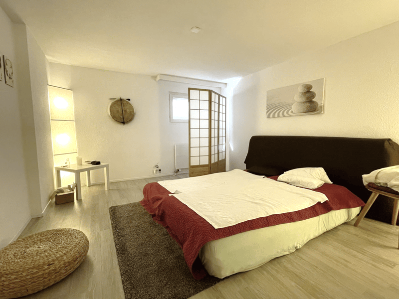 Bedroom with bed, rug, side table, and decorative items