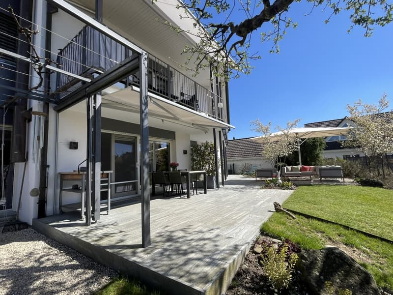 modern house, wooden deck, outdoor dining table, retractable awning, garden, trees