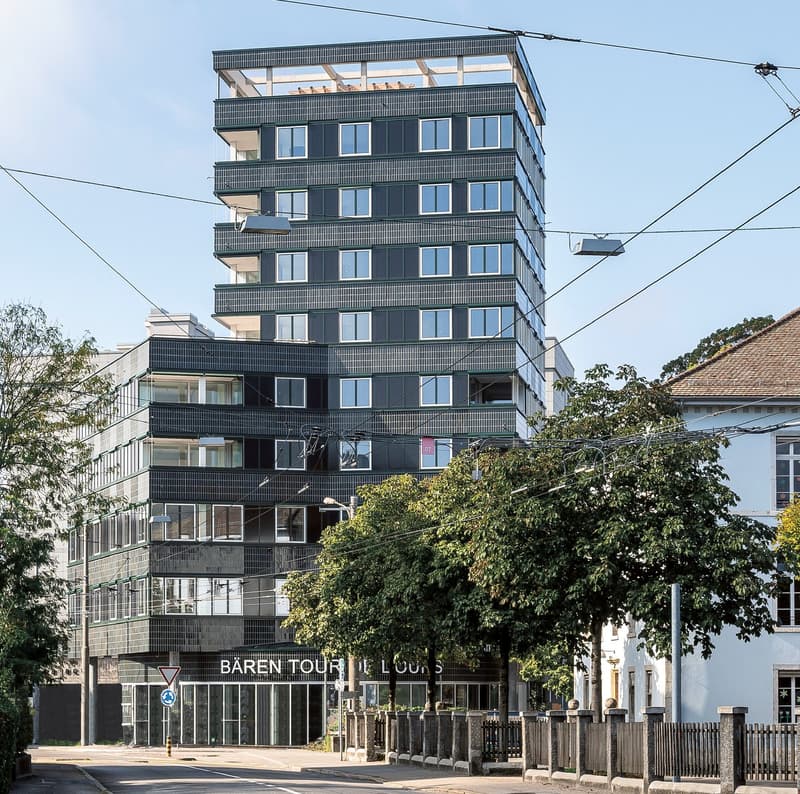 highrise building, modern design, black exterior, glass windows, terraces on upper floors, name 'Baren Tour' on front