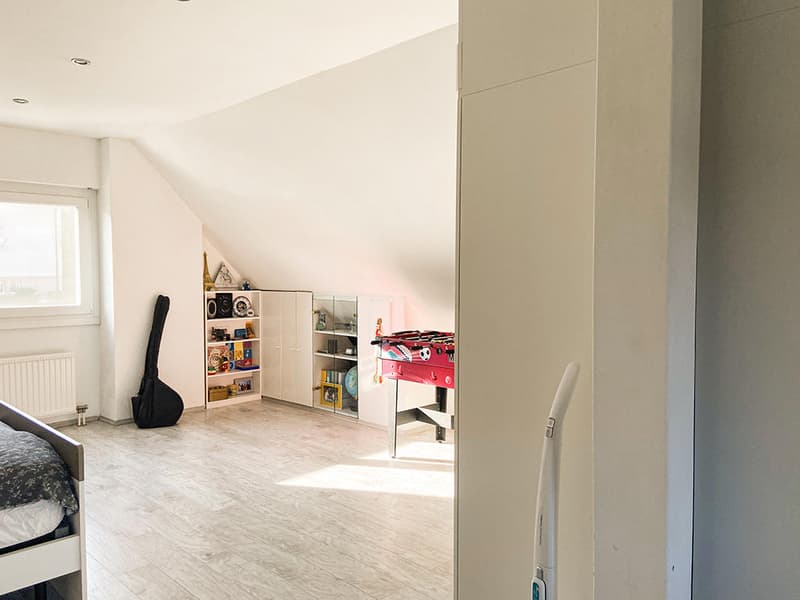 bedroom with bed, guitar, shelves, foosball table, radiator, window