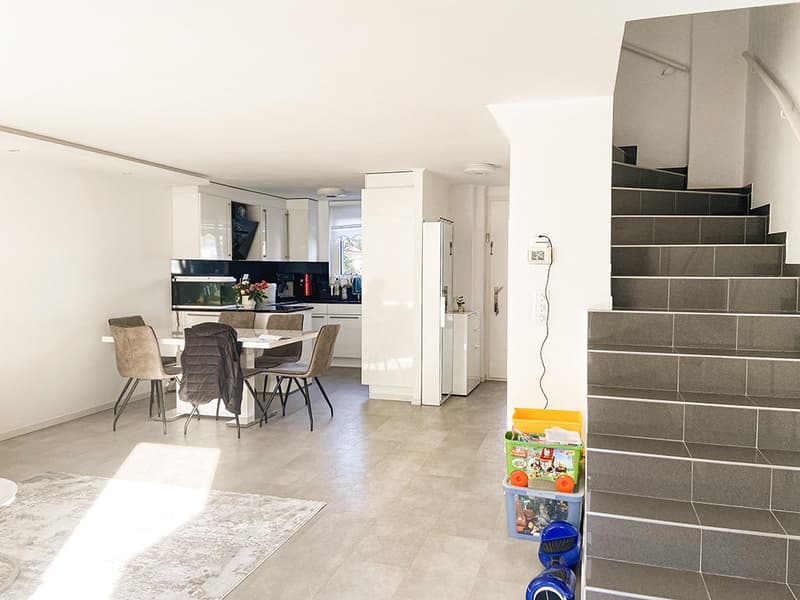 open floor plan, dining area with table and chairs, kitchen with appliances, staircase