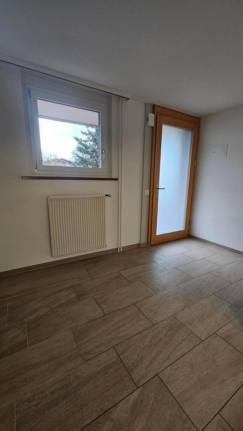 empty room, wooden floor, white walls, window, radiator, door