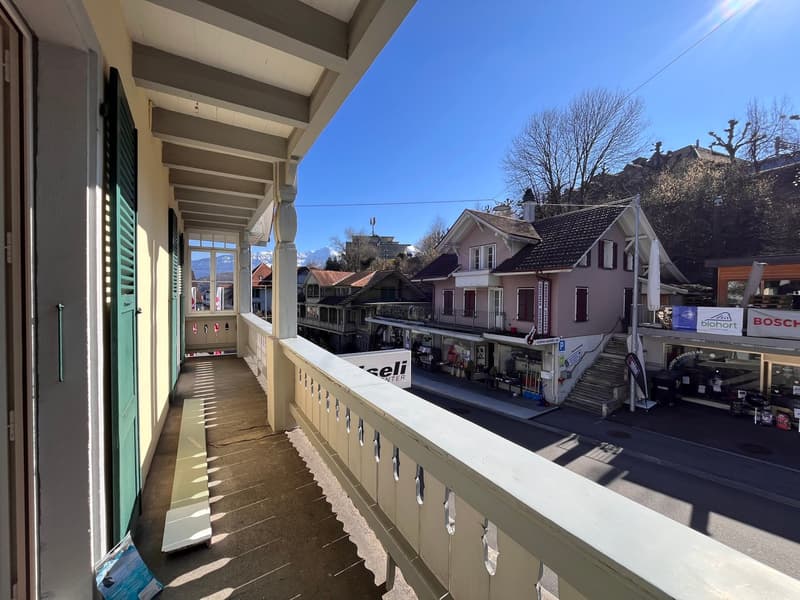 balcony with railings, view of the street and houses, mountains in the background