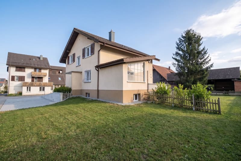 2 story house, beige and brown exterior, driveway, large lawn, trees, fence