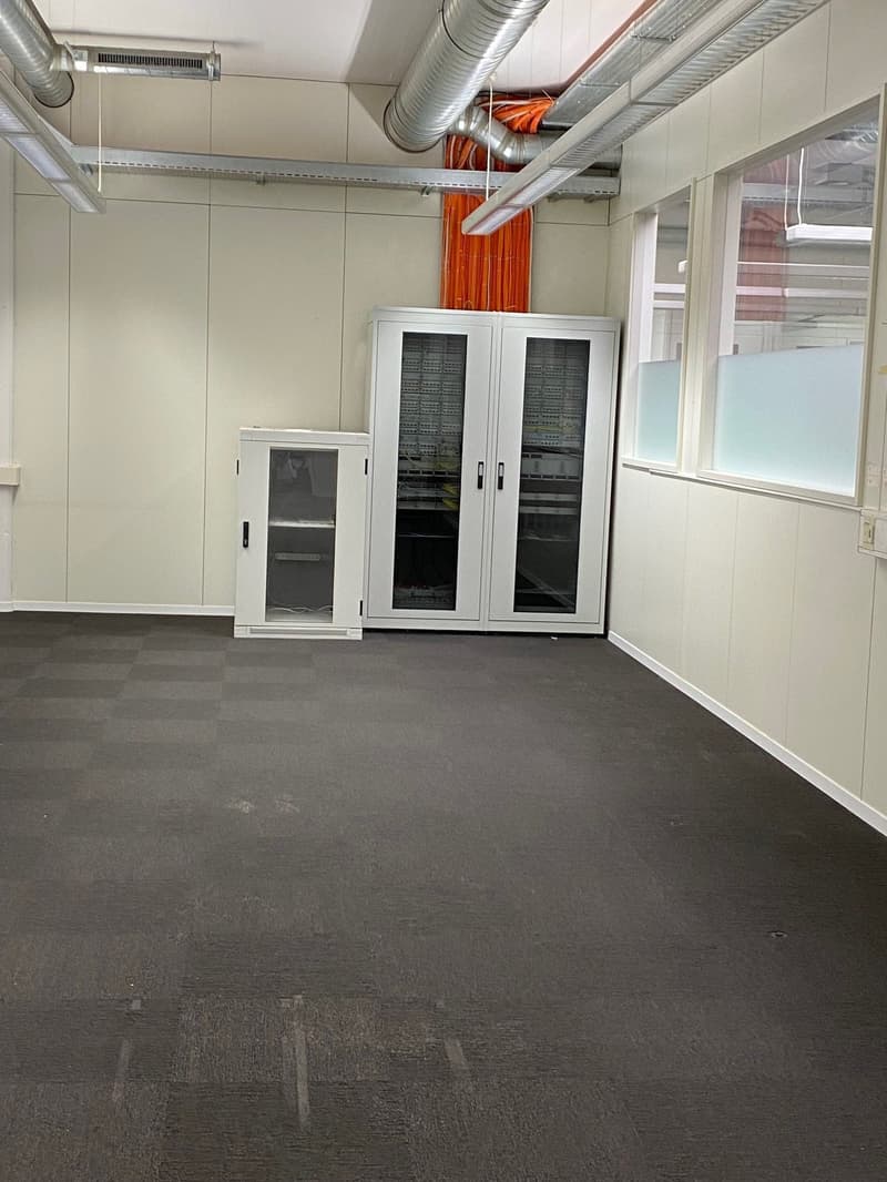 empty room, tiled floor, metal pipes, ceiling lights, white walls, white cabinets, windows