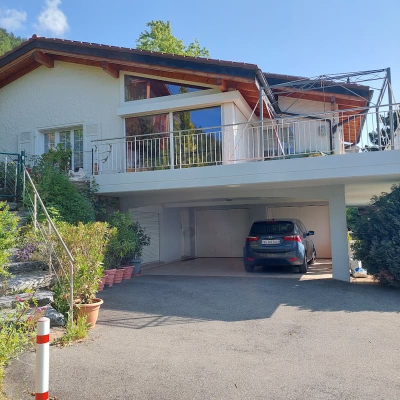 two story house, wooden balcony, garage, car parked in front, garden, view of trees