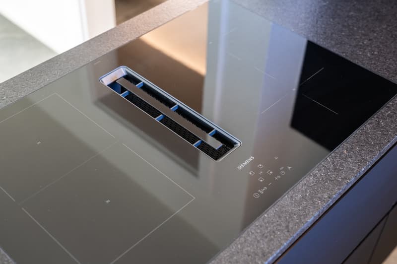 modern induction cooktop, Siemens brand, glass surface, control panel with icons