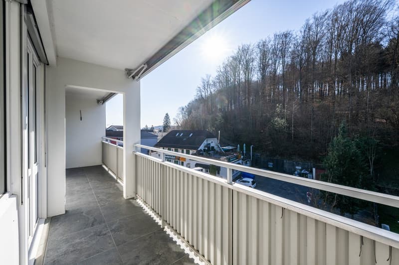 Balcony with railings, tiled floor, view of a house and trees
