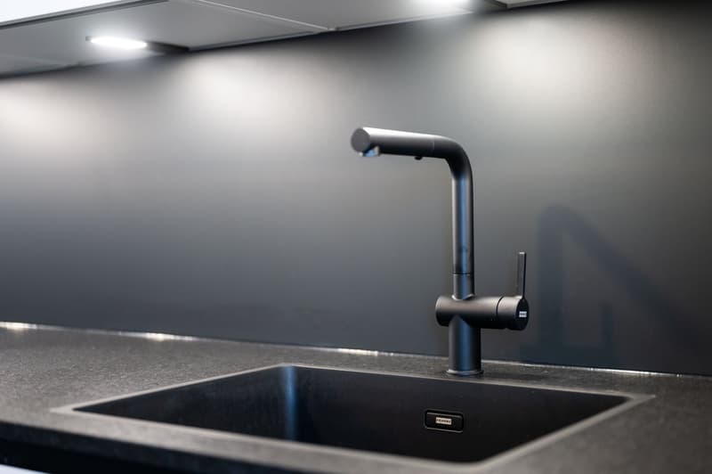 modern kitchen sink, black faucet, granite countertop, gray wall