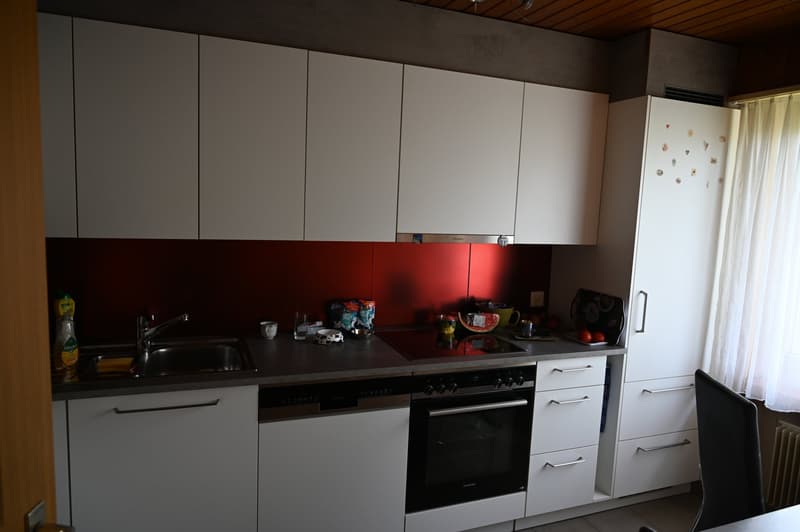 white cabinetry, red accent wall, stainless steel sink, oven, dishwasher, white refrigerator
