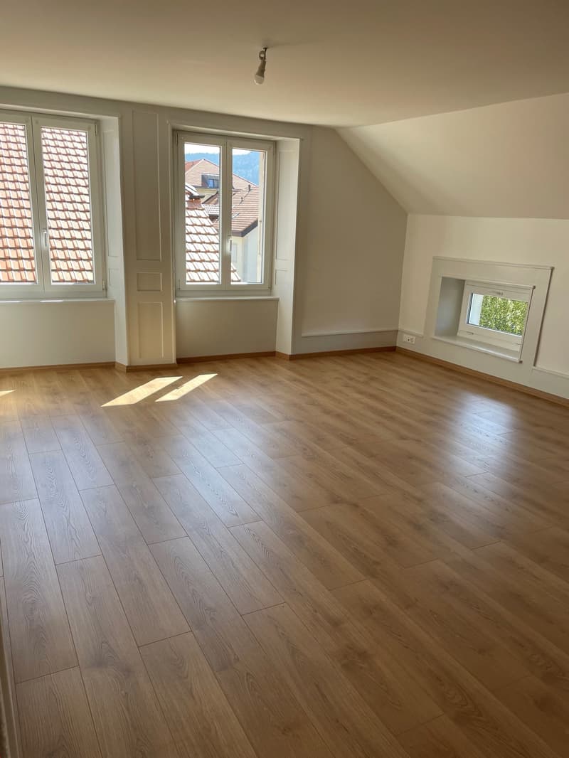 Wooden floor, three windows, light sunlight