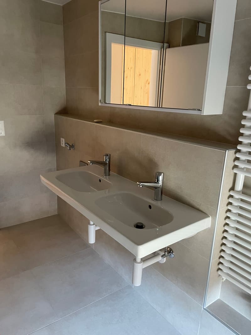 dual sinks, mounted mirror, tiled wall, towel rack